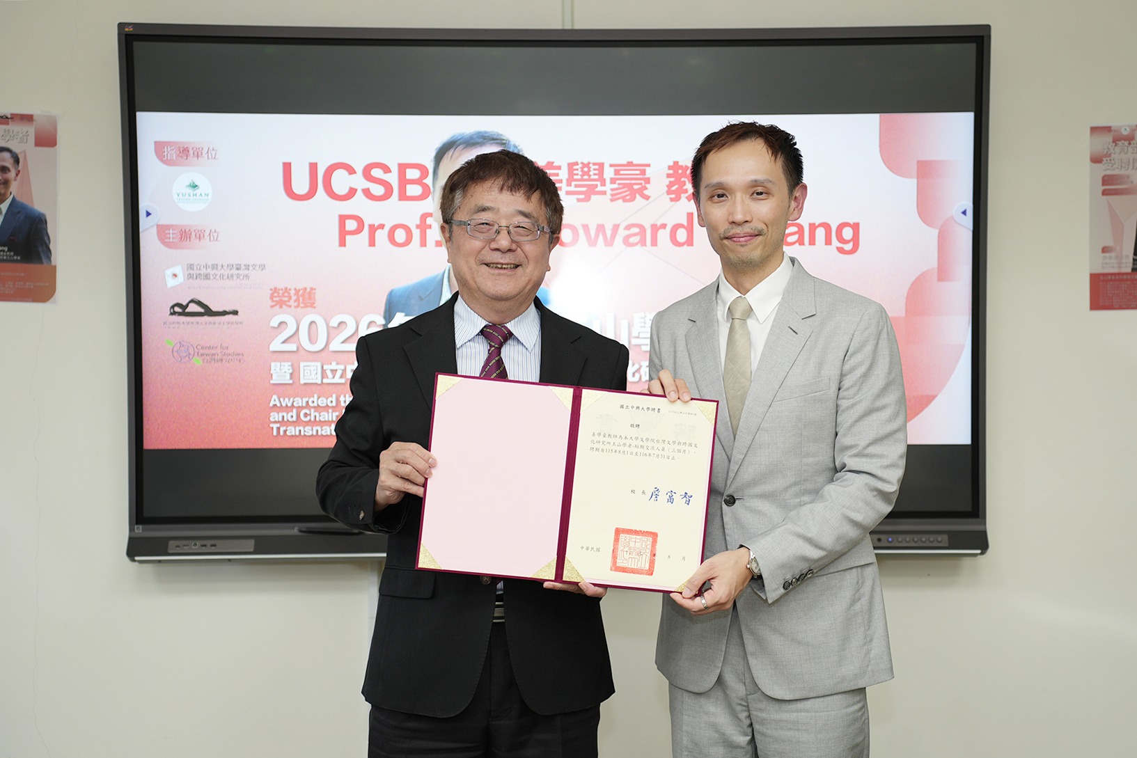 Howard Chiang, right, and NCHU President Fuh-Jyh Jan hold an open appointment document.